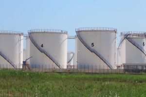 Tanker truck in motion on the road with oil depot in the background